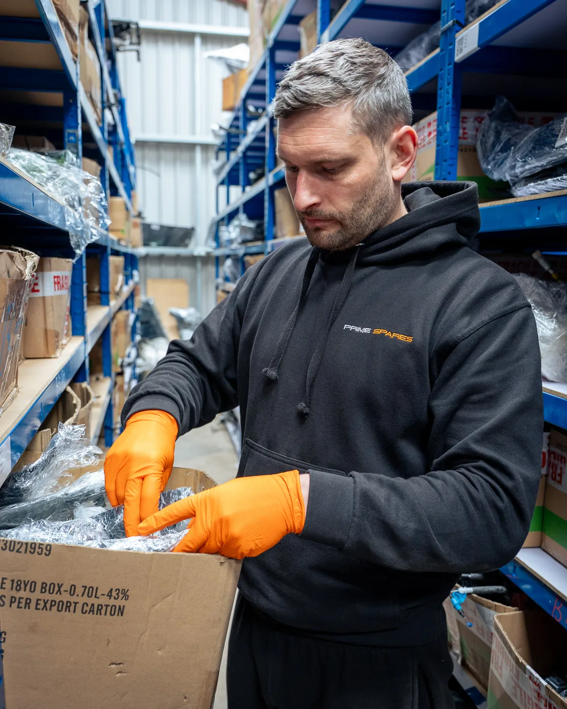 Prime Spares team member wrapping an automotive part at the packing station
