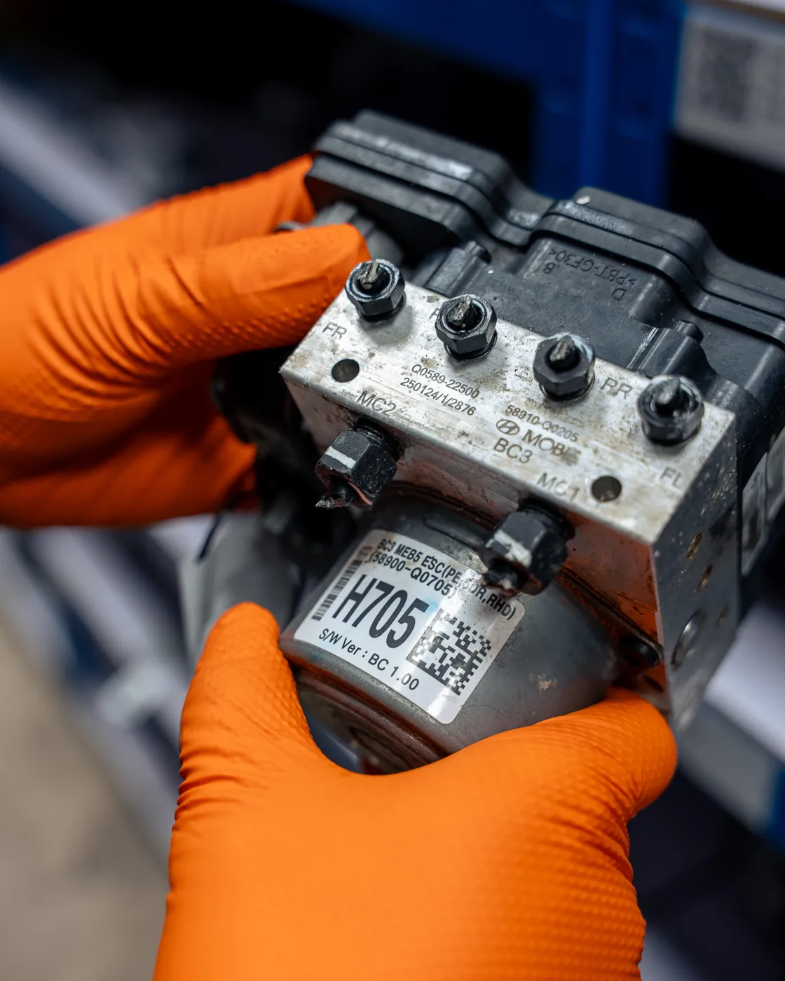 Prime Spares team member holding a labelled automotive part during stock identification