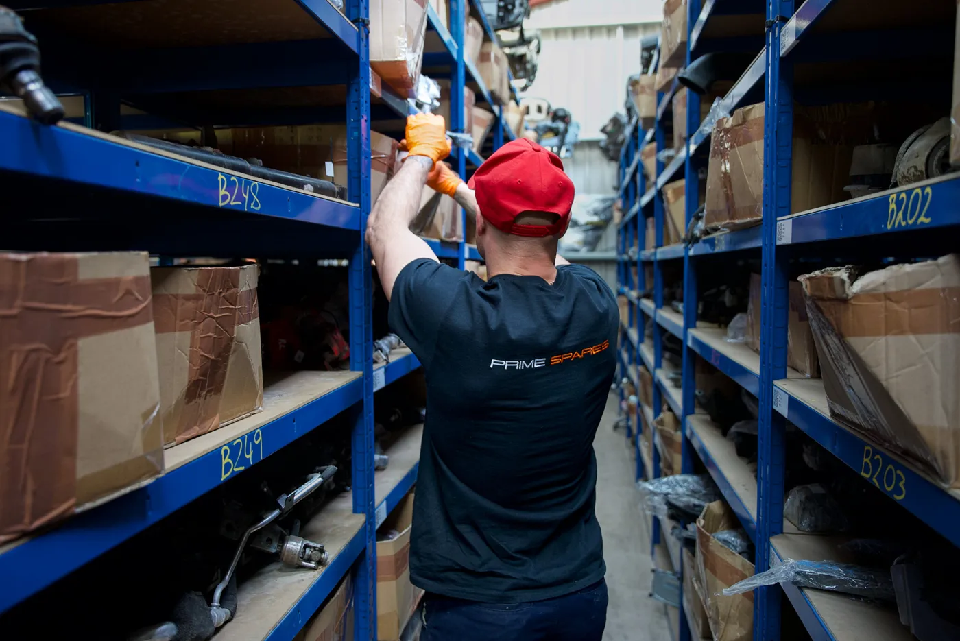 Prime Spares team member picking an automotive part from warehouse shelving